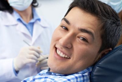 Smiling young man sitting in dentist's chair